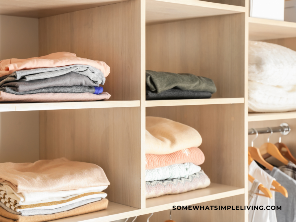 wood cubbies in a closet with folded sweaters