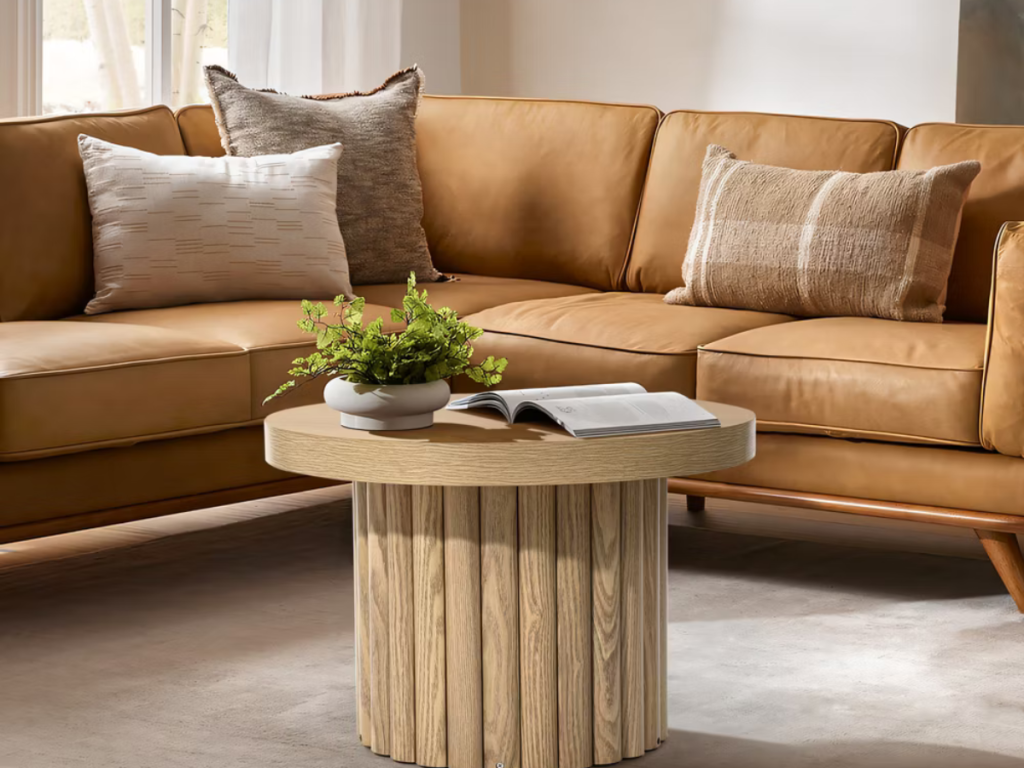 round coffee table with an open book and greenery