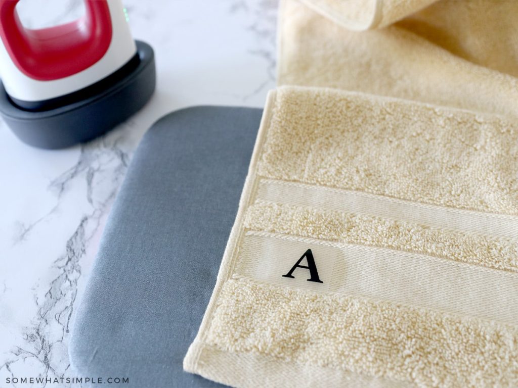 ironing on a letter A to a yellow towel