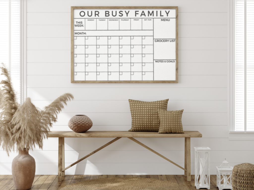 framed family calendar in an entry way over a bench