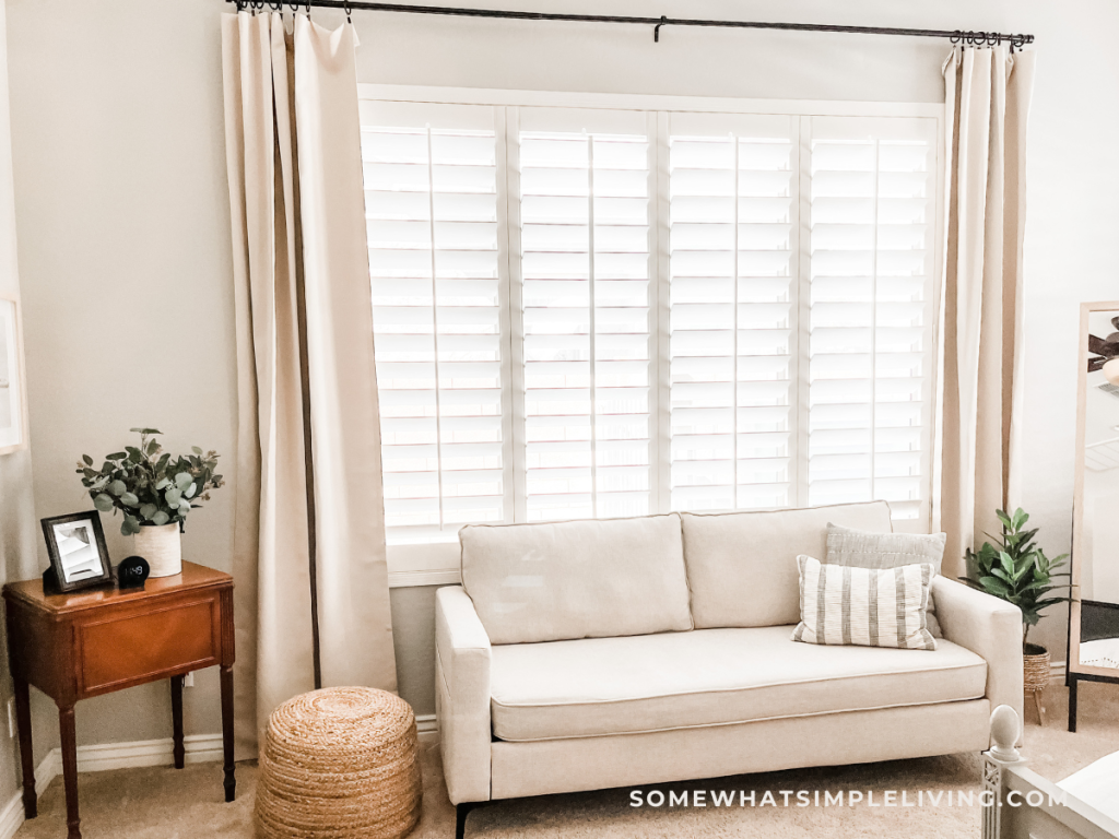 close up of the window area in a primary bedroom with beige curtains