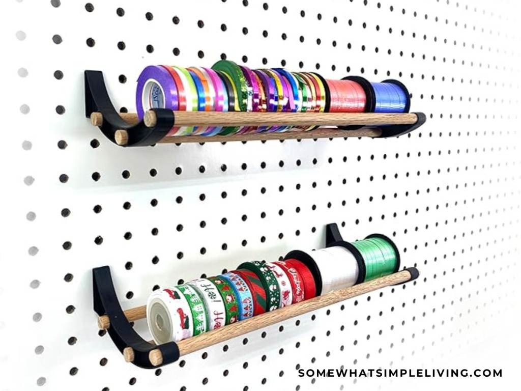 a pegboard with a shelf of ribbon spools