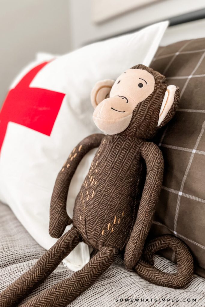 close up of a stuffed monkey on a boys bed