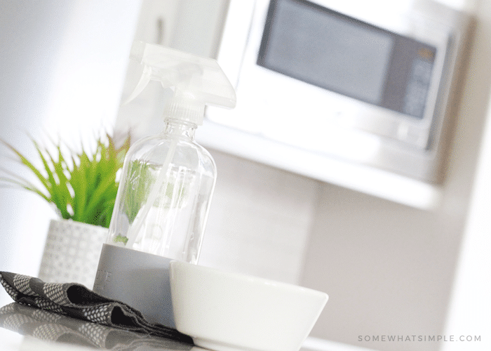 cleaning supplies in front of a microwave