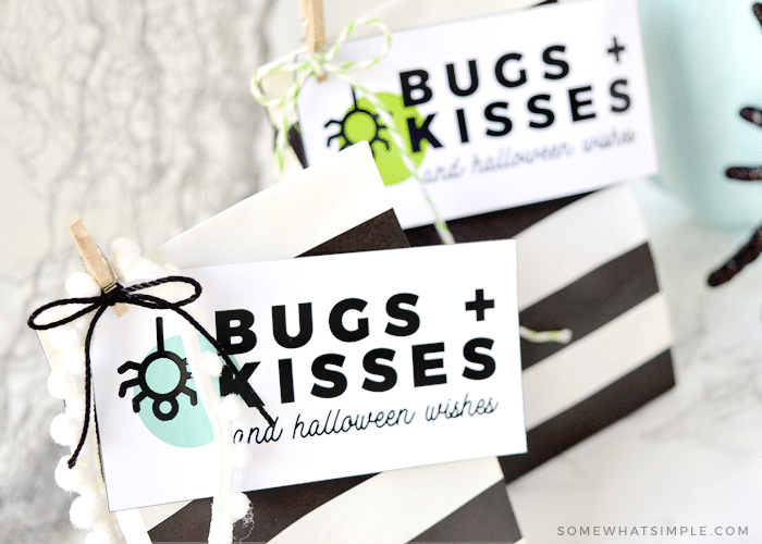 two halloween treat bags with a bugs and kisses tag attached to each one