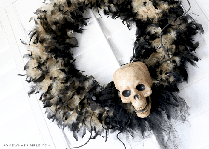 black halloween wreath with a fake skull attached with black ribbon