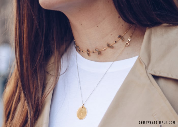 how to wear a necklace. pretty woman wearing a gold chain around her neck with a smaller necklace layered on top