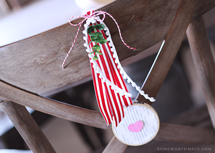 fabric and paper heart wreath hanging on the back of a chair