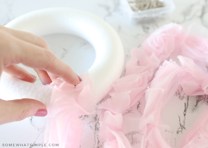 wrapping a wreath form in pink ruffly ribbon