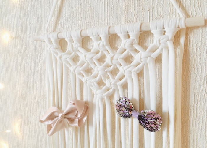 macrame wall hanging with bows clipped to the yarn