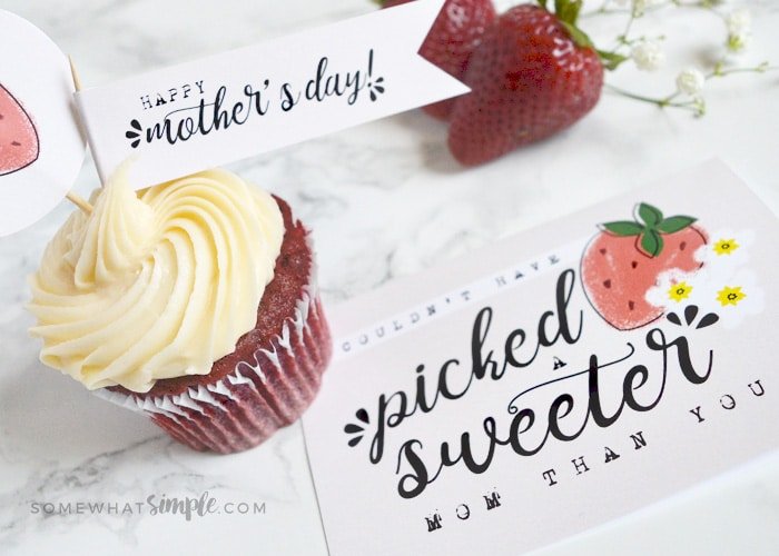a cupcake with frosting that has a tag that reads happy mother's day. next to the cupcake is a mothers day card free printable