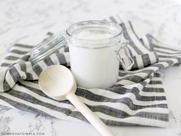 how to use coconut oil - jar of oil with wooden spoon on the counter
