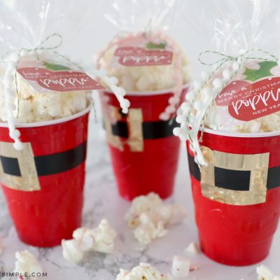 3 red solo cups decorated to look like santa's pants filled with popcorn