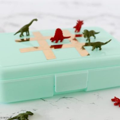 dinosaur tic tac toe markers on top of a plastic pencil box