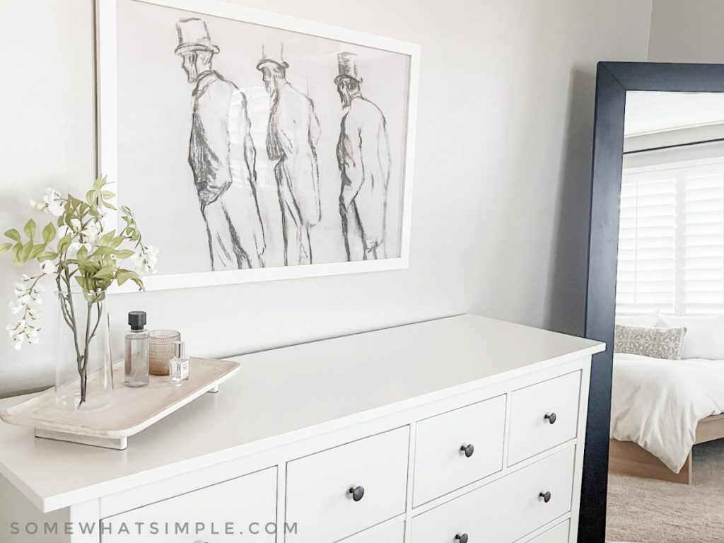 white dresser with artwork above it on the wall