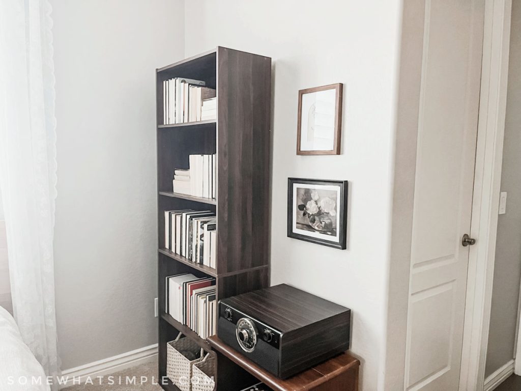 tall dark wood bookshelf filled with books next to a record player