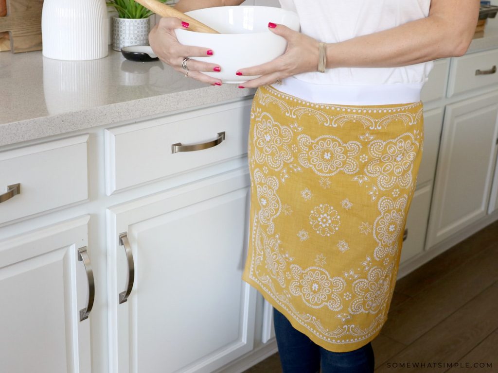 lady standing in the kitchen wearing a bandana apron