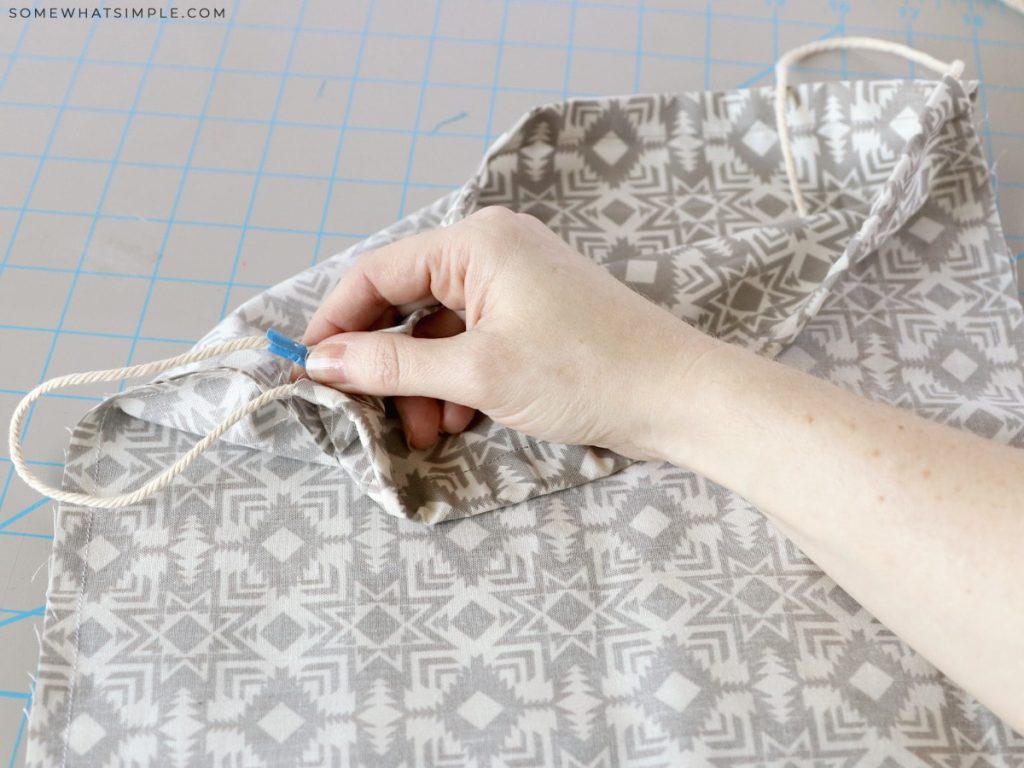 weaving string through a bag to make it a backpace