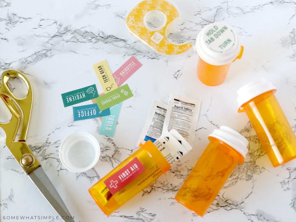 pill bottles scattered on a counter next to labels and scissors