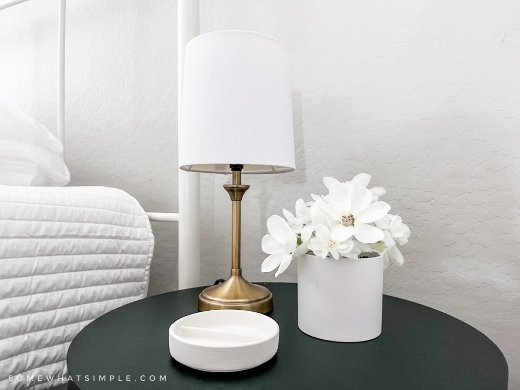 close up of lamp and flowers on a night stand