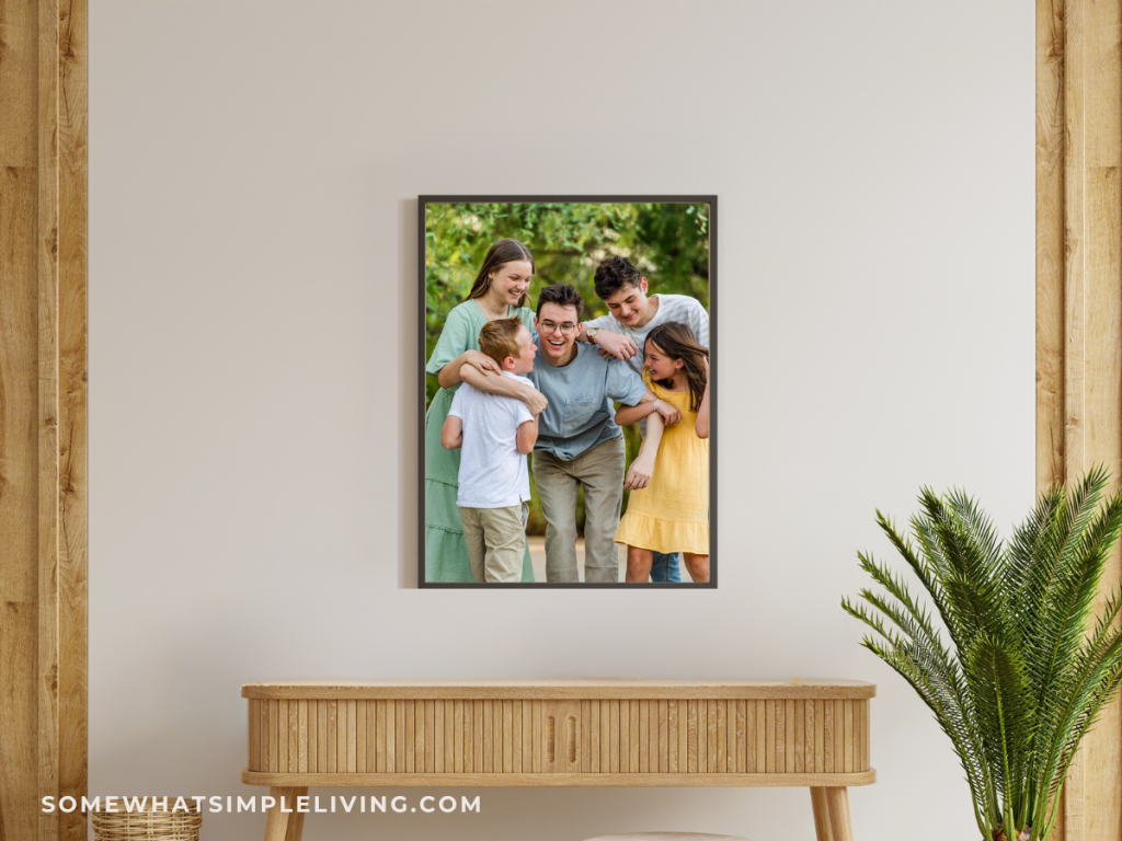 wood console table with a framed picture of kids centered on wall above it