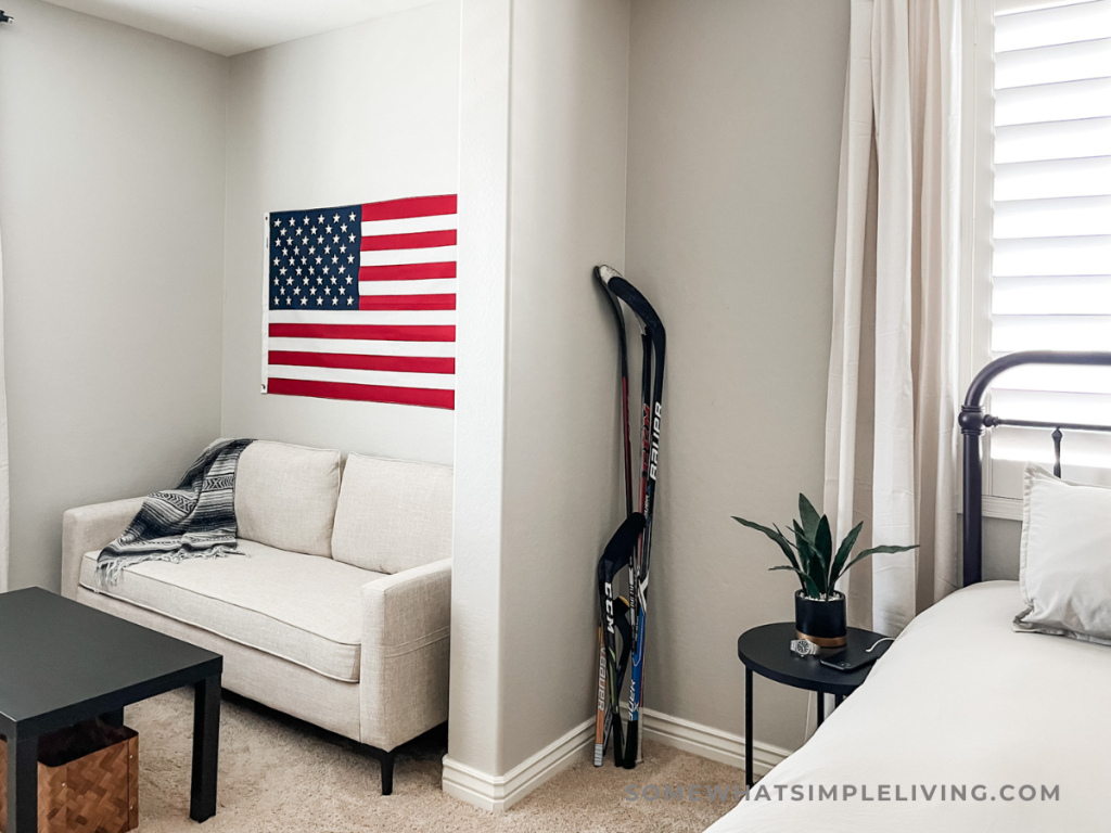 the corner of a teen boy's bedroom with hockey sticks leaning against the wall