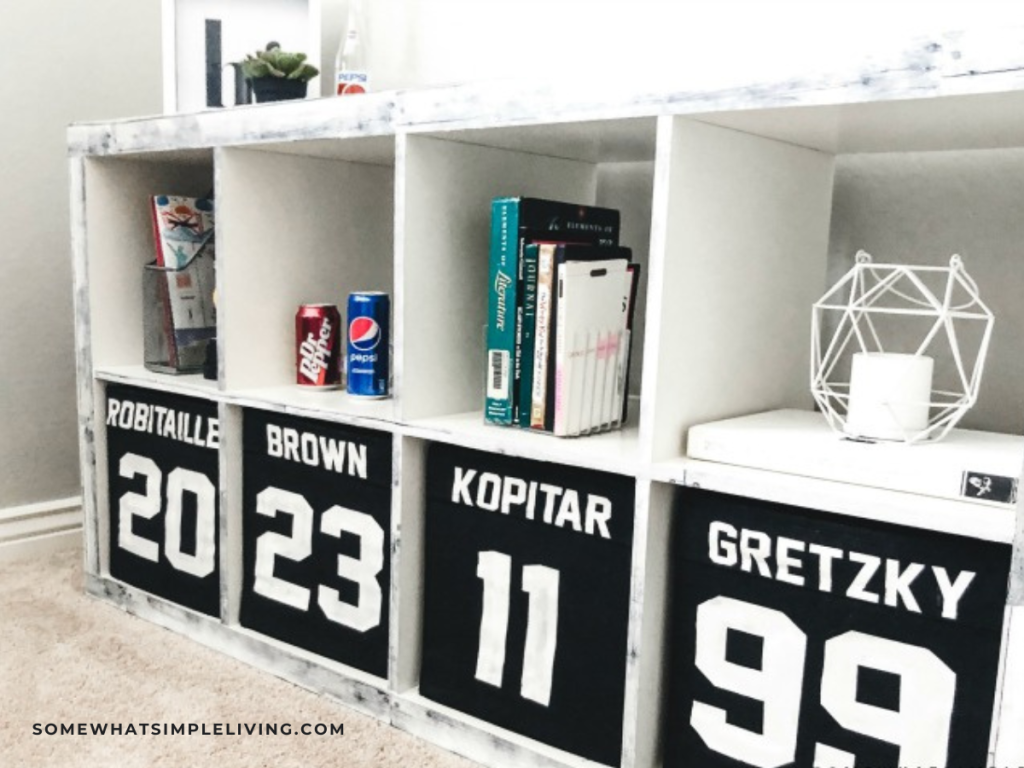 close up of a shelf in a boys bedroom with hockey players jerseys on the cubbies