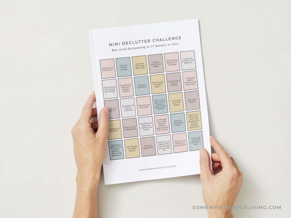 womans hands holding a mini declutter challenge calendar