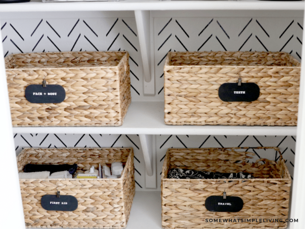 wicker baskets with labels in a bathroom closet