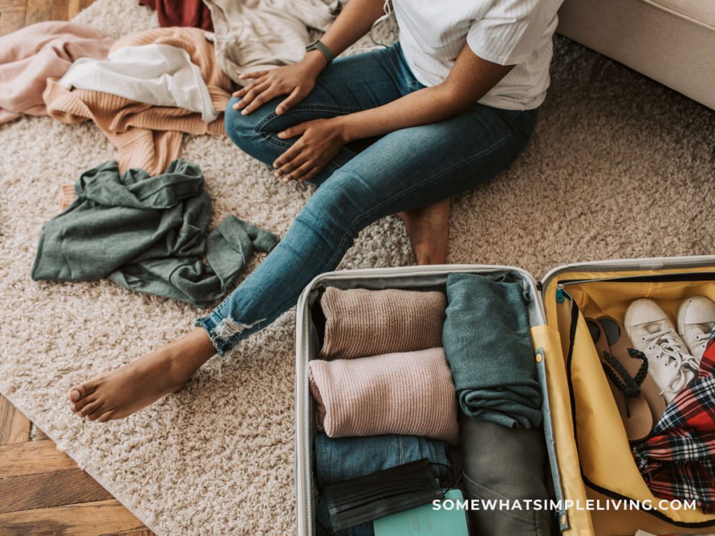 woman sitting on the floor packing a suitcase