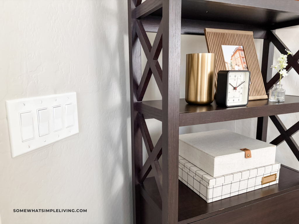 light switch next to a tall bookshelf