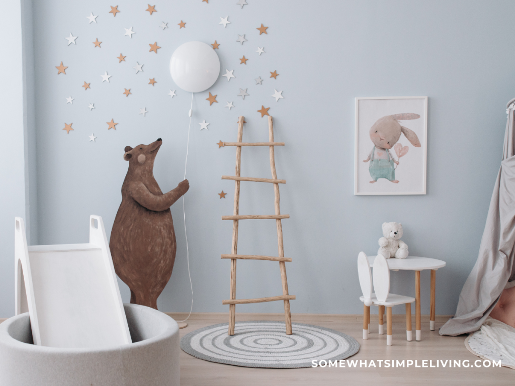 light blue playroom with a bear on the wall holding a white balloon