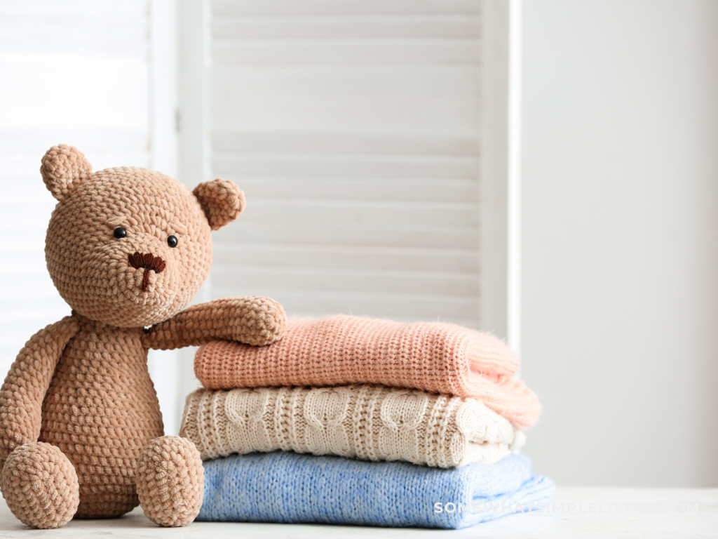 teddy bear next to stack of clothes