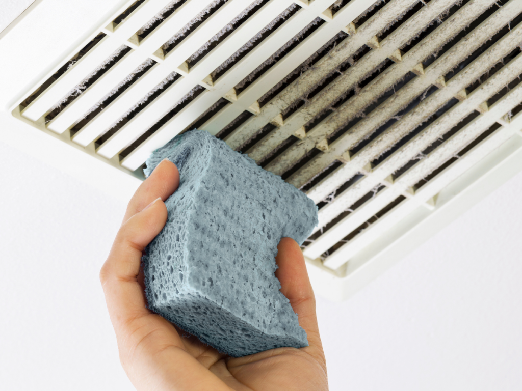 sponge cleaning a ceiling vent