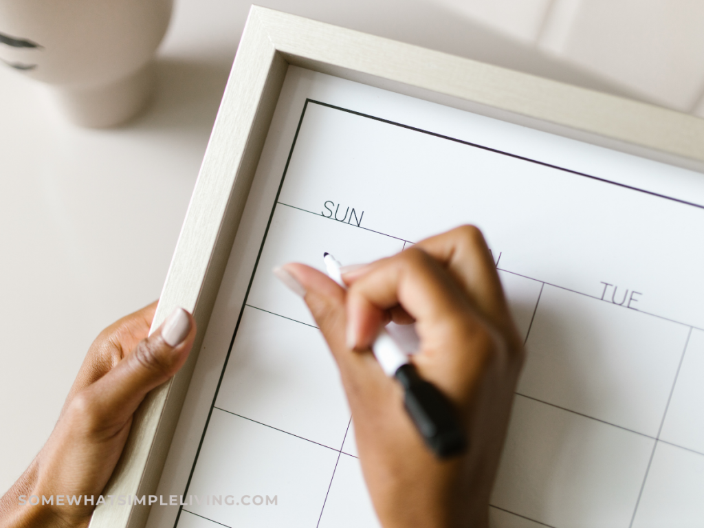 woman's hand writing on a calendar