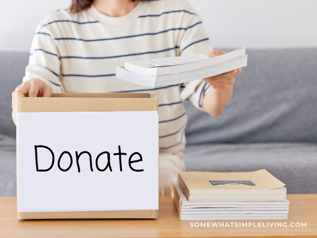woman putting books in a brown box labeled "donaet"