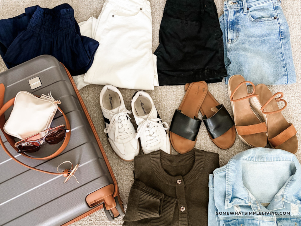 clothes for a trip laid out next to a suitcase