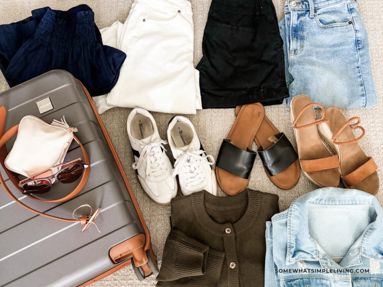 clothes for a trip laid out next to a suitcase