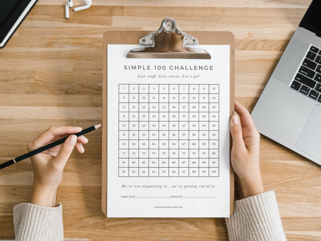 woman holding a clipboard with a checklist of 100 things to declutter