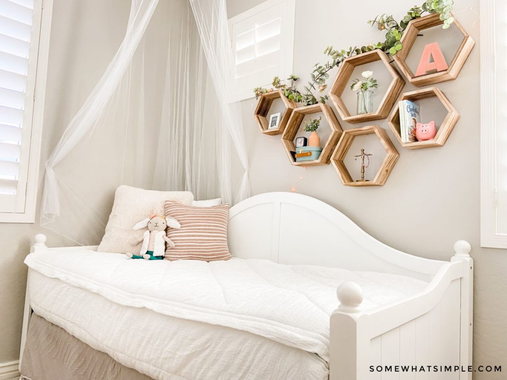 white day bed made for a little girls room with a mosquito net in the corner